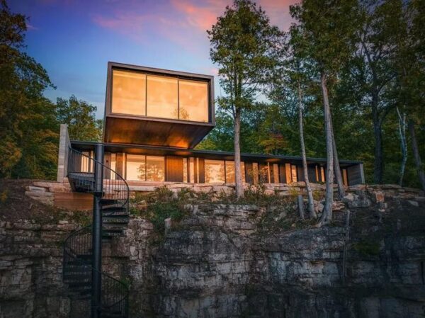 Spiral staircase outside a beautiful home on a dliff at sunset